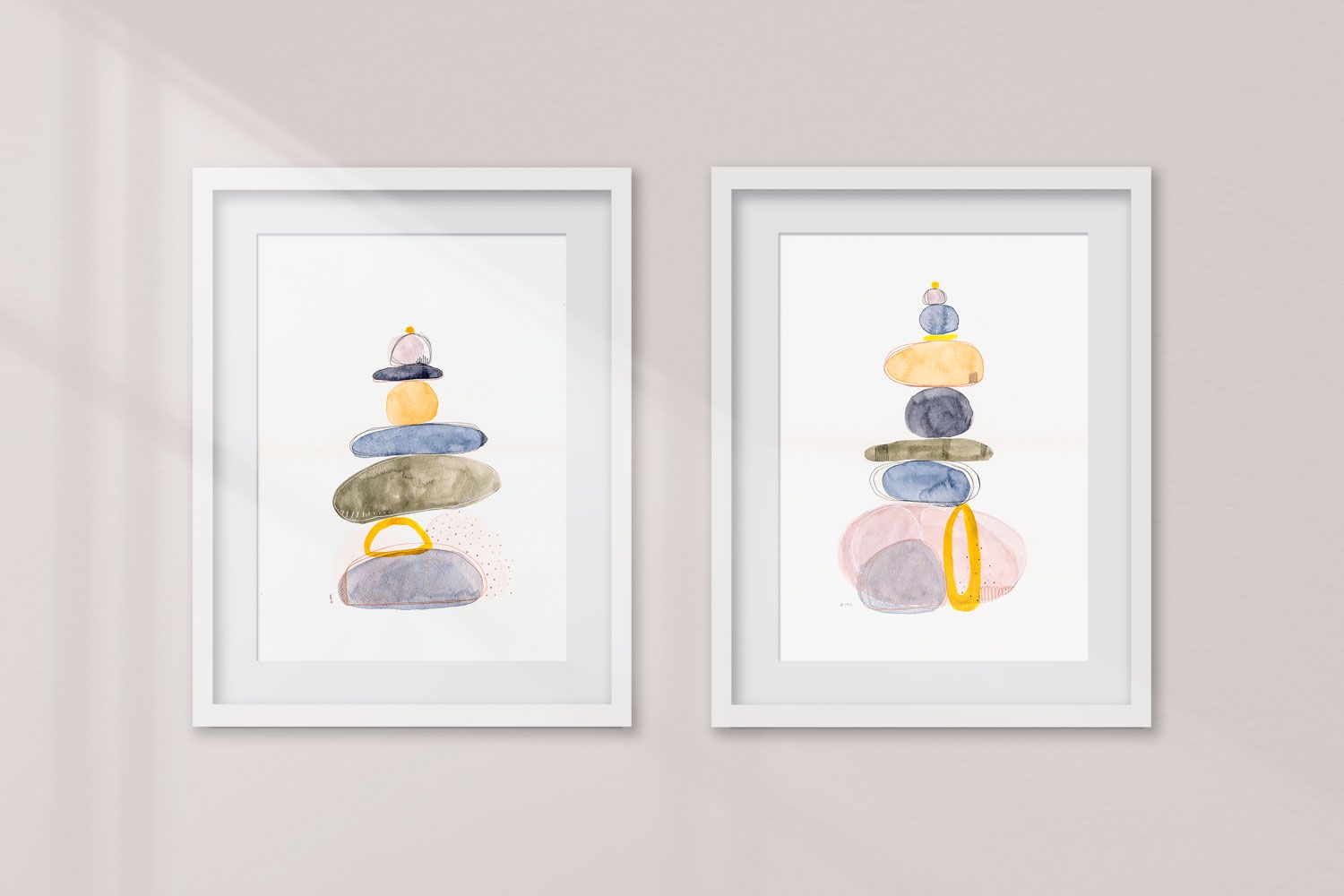 conjunto de 2 acuarelas modernas piedras con colores azul verde y amarillo titurada "Rock balance aro amarillo I y II" de emegrande. Con marco colgadas en pared